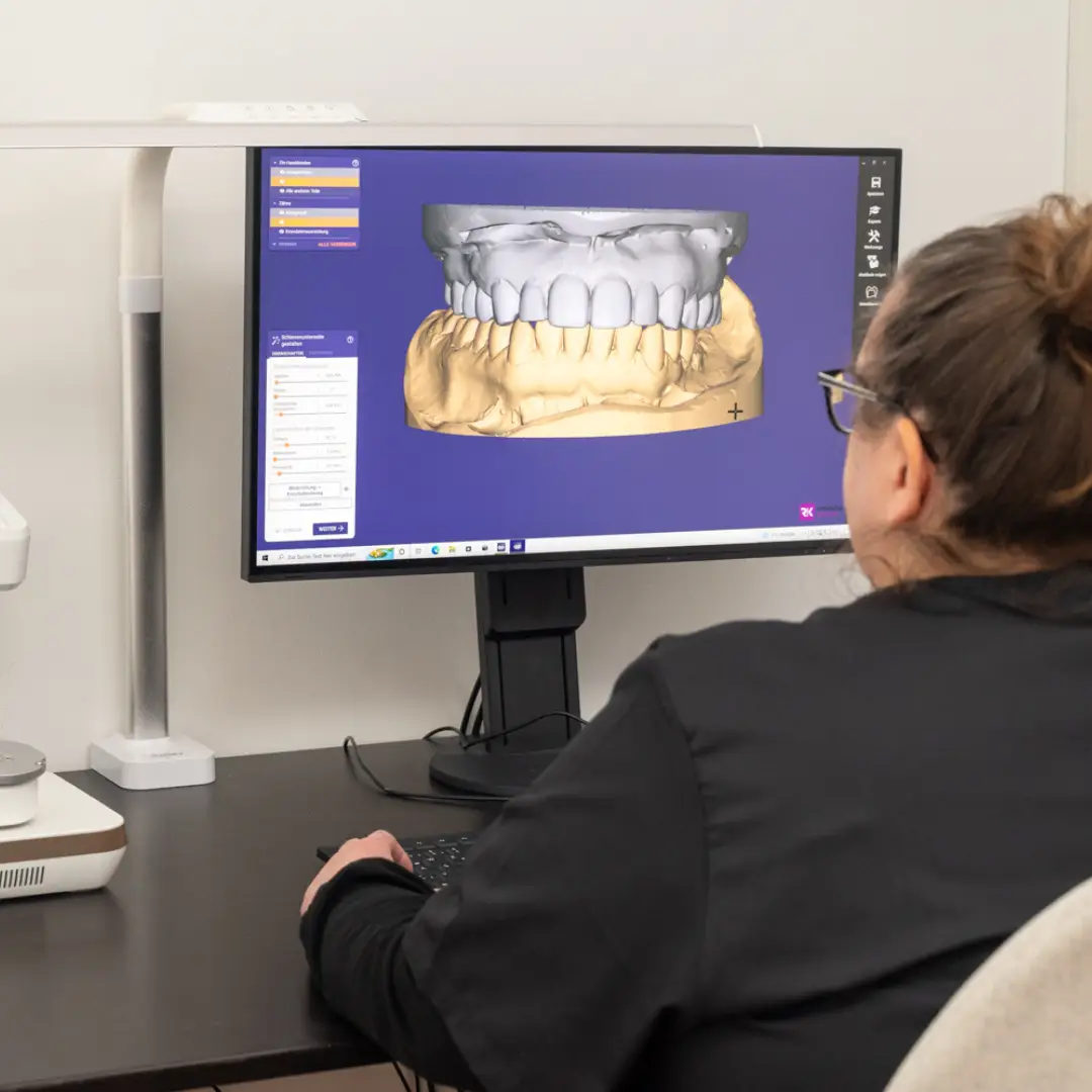 Zahntechnikerin erstellt mit modernster Technologie ein 3D-Modell eines Gebisses.